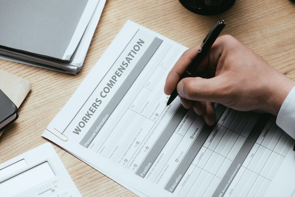 cropped view of man filling in Workers Compensation Accident Injury Concept