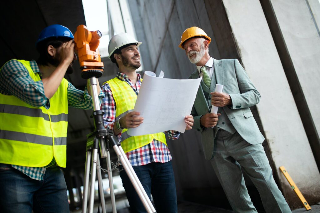 Engineer and construction site manager dealing with blueprints and plans