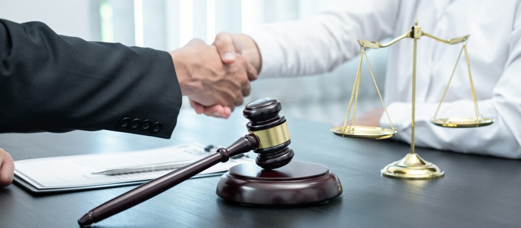 Male lawyer shaking hands with client after good deal negotiation cooperation meeting in courtroom